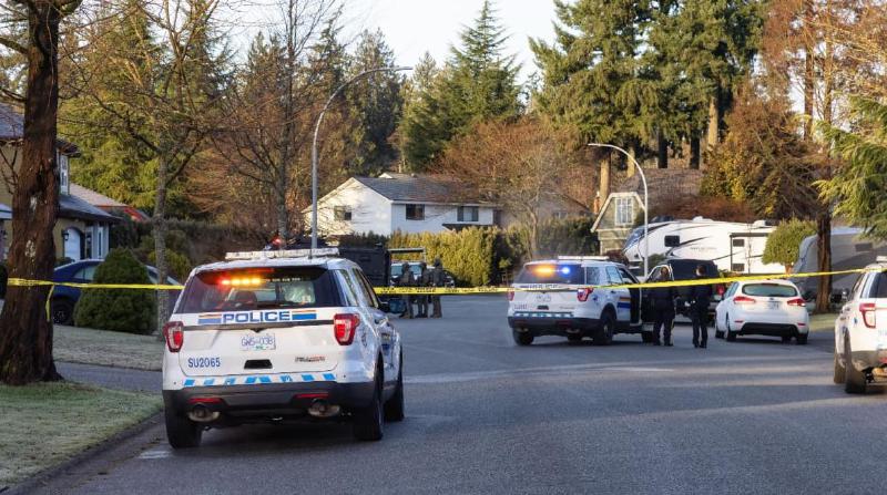 Police with cars and a SWAT team at a house in the suburbs of British Columbia