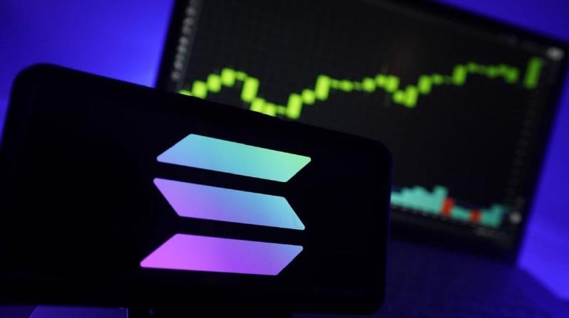 An image of the Solana (SOL) logo with a rising crypto price chart visible on a screen in the background
