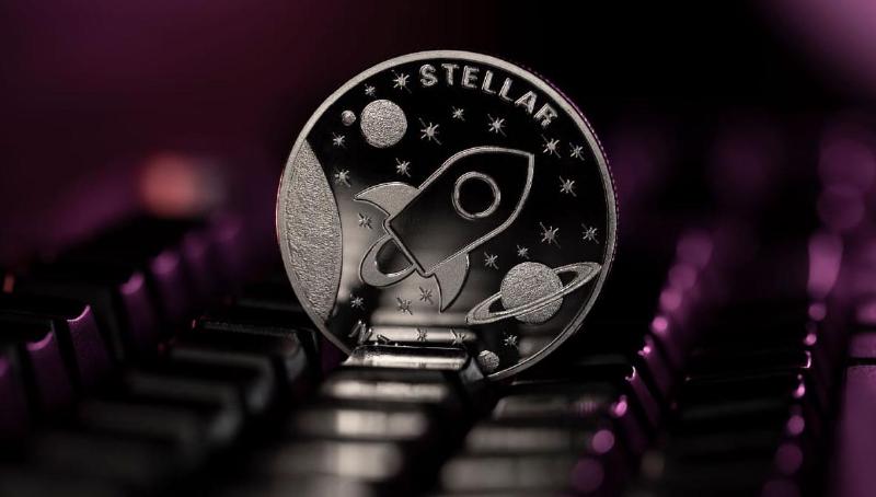 An image of the cryptocurrency Stellar (XLM) next to a computer